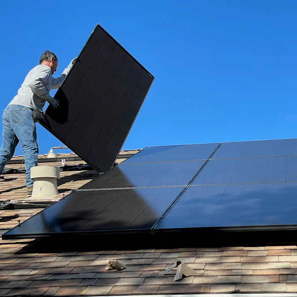 Installateur posant un panneau solaire sur un toit